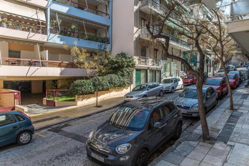 a row of cars parked on a city street at Olympus Residence in Athens
