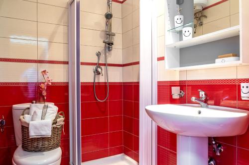 bagno rosso con lavandino e servizi igienici di Pippo House a Giardini Naxos