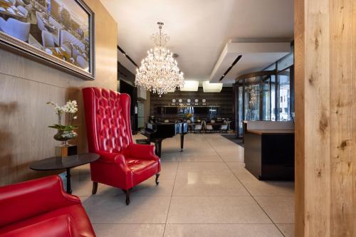 a waiting room with red chairs and a chandelier at Pepperclub Hotel in Cape Town
