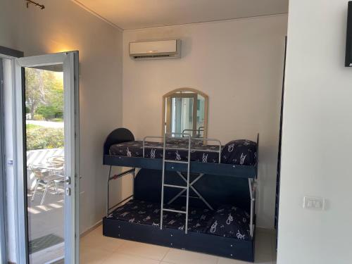 a room with a bunk bed with a mirror at Baia Sangiorgio Hotel & Beach Club in Bari