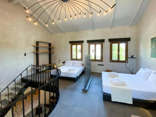 a large room with two beds and a staircase at Lethe Villas with Private Pool Kato Gatzea Greece in Kato Gatzea