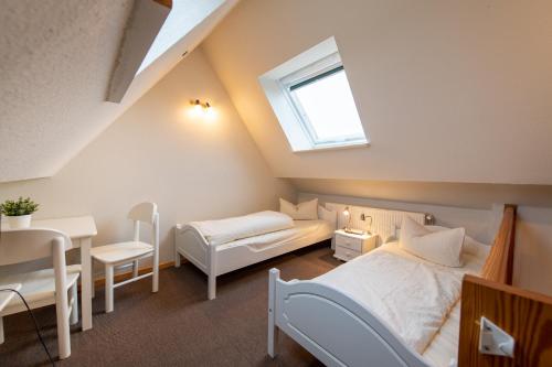 a bedroom with a bed and a table and a window at Landhaus Jägerhof in Börnsdorf