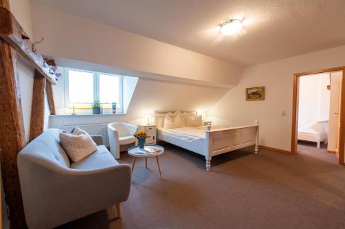 a living room with a bed and a couch at Landhaus Jägerhof in Börnsdorf