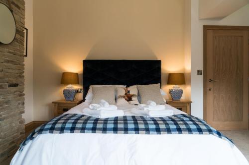 a bedroom with a large white bed with two lamps at The Pickled Pheasant in Holmfirth