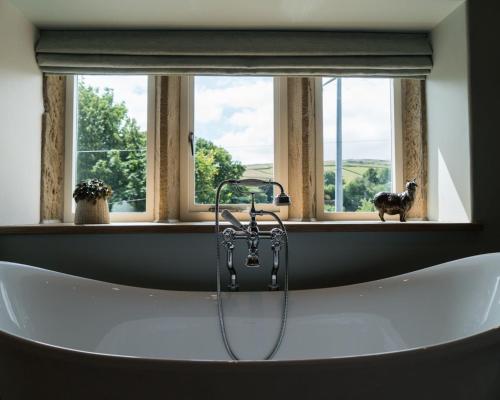 a bath tub in a bathroom with a window at The Pickled Pheasant in Holmfirth