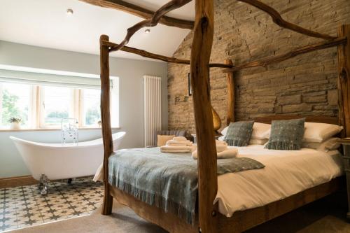a bedroom with a large bed and a bath tub at The Pickled Pheasant in Holmfirth
