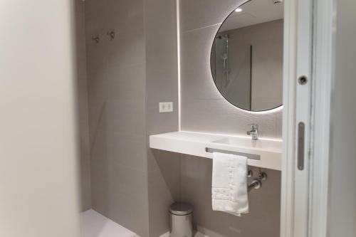 HOTEL ORDIZIA في Villafranca de Ordizia: حمام أبيض مع حوض ومرآة