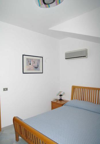 a bedroom with a bed and a picture on the wall at Residence Fontana Barone in Cefalù