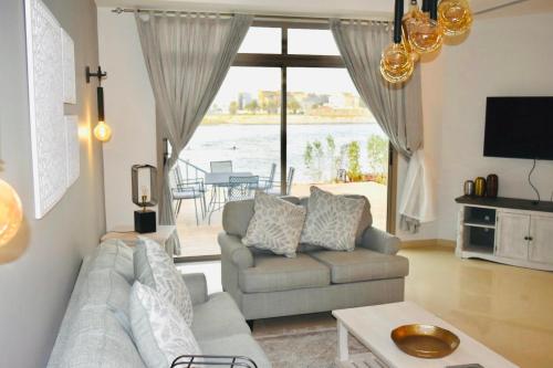 a living room with a couch and a large window at Amwaj Resort For Families Only in Al Khobar