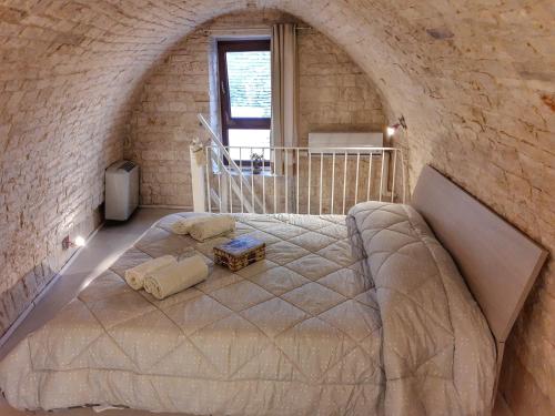 una camera con un grande letto in un muro di mattoni di Mirum Apuliae 16 ad Alberobello