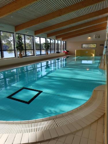 a large swimming pool with blue water in a building at Lehmirannan Lomakeskus in Salo