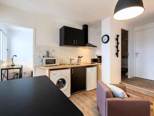 a kitchen and living room with a black table in a room at NYC gare in Clermont-Ferrand