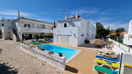 Casa blanca con piscina y sillas en Villa Gabriel by Sunny Deluxe, en Albufeira