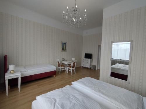 a bedroom with two beds and a table and a chandelier at Liahof in Ullared