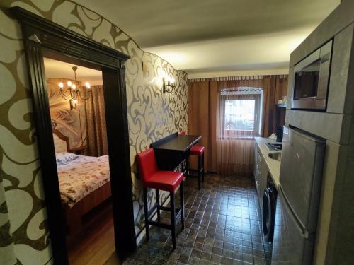 a hotel room with a bed and a table with a red chair at CezAri ApartHotel in Braşov
