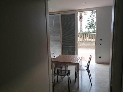 a dining room with a wooden table and chairs at Zibibbo Beach Apartments - Trapani in Trapani