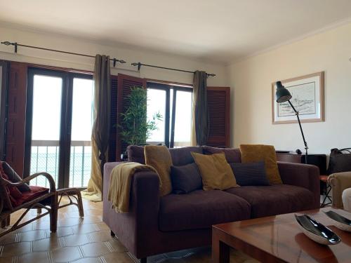a living room with a couch and a table at Casa vista Azul in Sesimbra