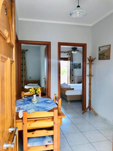 a room with a bedroom with a table and a mirror at Aigeiros Apartments & restaurant in Skala Mistegnon