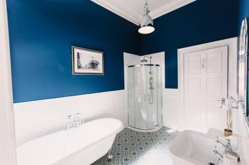 a blue and white bathroom with a tub and a sink at Stewart Apartment - A unique Apartment in countryside park with WIFI and access to bar and pool in Perth