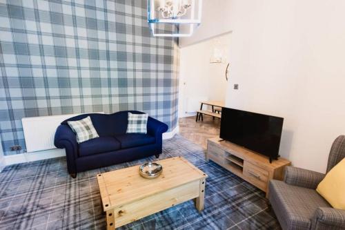 a living room with a blue couch and a tv at Stewart Apartment - A unique Apartment in countryside park with WIFI and access to bar and pool in Perth