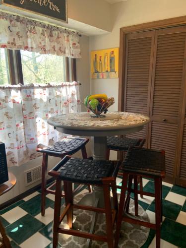 a table with four chairs and a bowl of fruit on it at Jackson’s Stone Mountain Hideaway in Stone Mountain