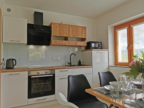 a kitchen with a table and chairs and a kitchen with a stove at Apartment Vida in Bled