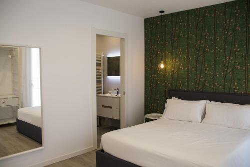 sypialnia z białym łóżkiem i zieloną ścianą w obiekcie Bloom Apartments w Trydencie