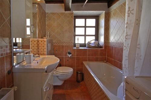 La salle de bains est pourvue d'une baignoire, de toilettes et d'un lavabo. dans l'établissement Sweet Cottage Vendégház, à Gyenesdiás