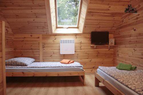 um chalé de madeira com 2 camas e uma televisão em Pod Brzozami Apartamenty Domek Ustronny em Ustronie Morskie