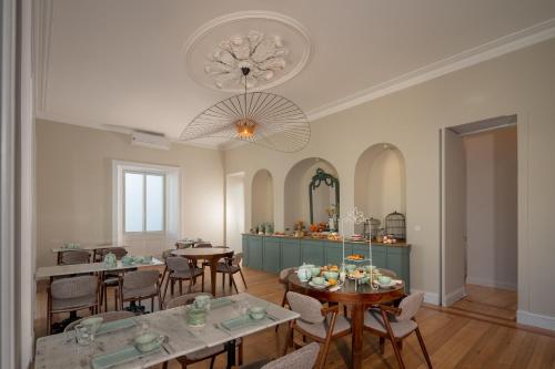 a dining room with tables and chairs and a chandelier at Casa do Pateo - Charming House Azores in Ponta Delgada