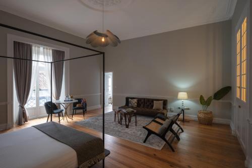 um quarto com uma cama e uma sala de estar em Casa do Pateo - Charming House Azores em Ponta Delgada
