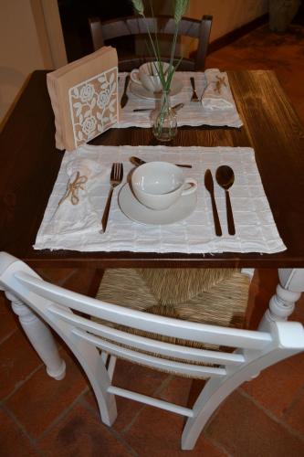 a wooden table with a white table cloth and utensils at La Locanda nel Frutteto in Rovereto