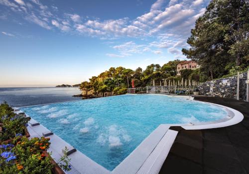 a swimming pool with a view of the ocean at Excelsior Palace Portofino Coast in Rapallo