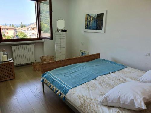 een slaapkamer met een bed met een blauwe deken erop bij Welcome Traveller LA PERLA APARTMENTS in Garda