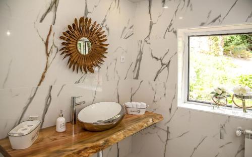 a bathroom with a counter with a sink and a mirror at Casa da Pontelha by Gerês Casas in Terras de Bouro