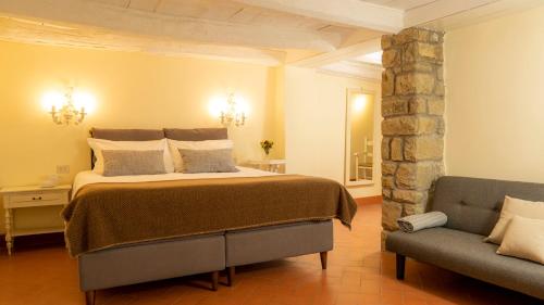 a bedroom with a large bed and a couch at Fattorie di Celli in Poppi