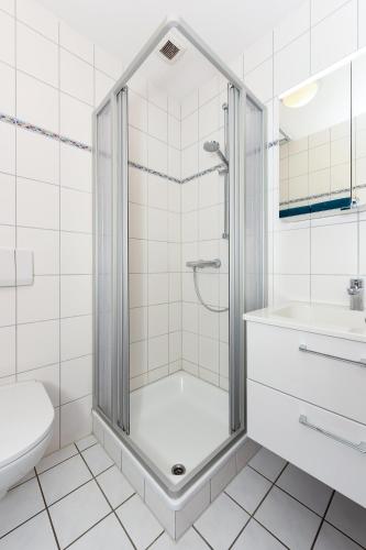 a bathroom with a shower and a toilet and a sink at Ferienwohnung Deichblick in Bensersiel