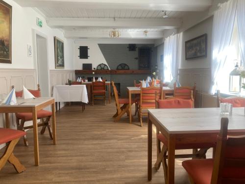 a dining room with wooden tables and chairs and a tables and chairsktop at Hotel Die Friesenhalle in Bredstedt