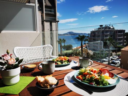 stół z dwoma talerzami jedzenia na balkonie w obiekcie Superior Calpe Pearl Beach w mieście Calpe