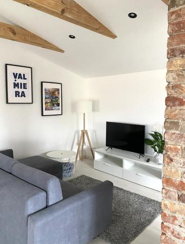 a living room with a couch and a tv at West Key Apartment in Valmiera