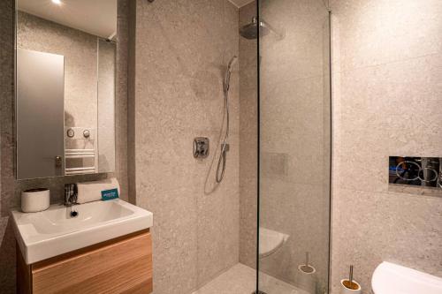 une salle de bain avec une douche et un lavabo et une douche dans l'établissement 136 - Urban Beaumarchais Voltaire, à Paris