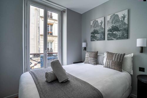 une chambre avec un grand lit blanc avec une fenêtre dans l'établissement 136 - Urban Beaumarchais Voltaire, à Paris
