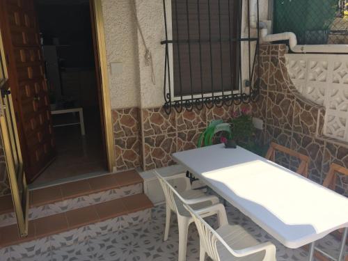 - une table et des chaises blanches sur la terrasse dans l'établissement Bungalow dúplex (Gran Playa - Playa Lisa), à Santa Pola