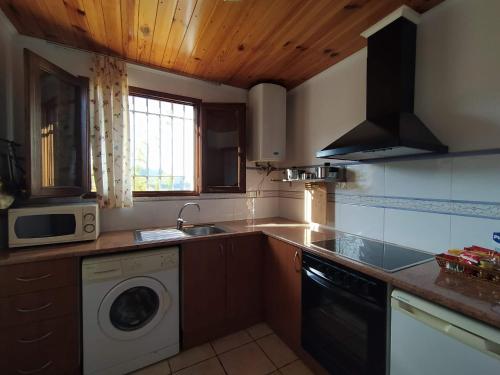 a kitchen with a sink and a washing machine at Les Eres de Gátova in Gátova