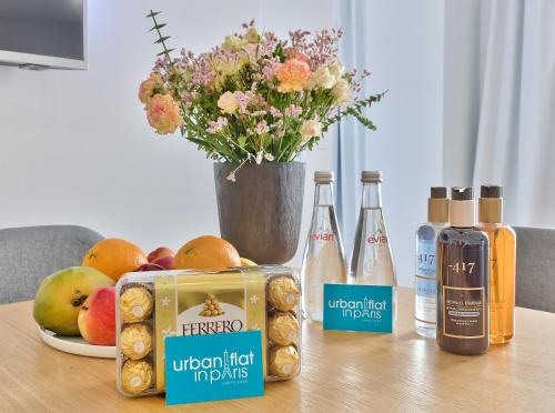une table avec des bouteilles d'alcool et un vase de fleurs dans l'établissement 127 - Urban Beautiful 4BR in Montorgueil, à Paris