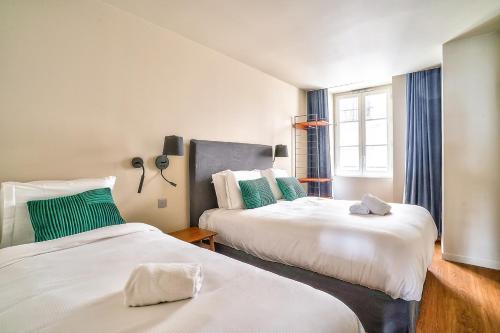 - 2 lits dans une chambre de couleur verte et blanche dans l'établissement 133 - Urban Amazing Flat Montorgueil, à Paris