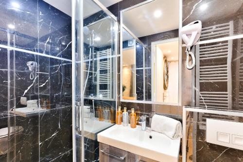 La salle de bains est pourvue d'un lavabo et d'une douche en verre. dans l'établissement 113 - Urban Vuitton Lemoine, à Paris