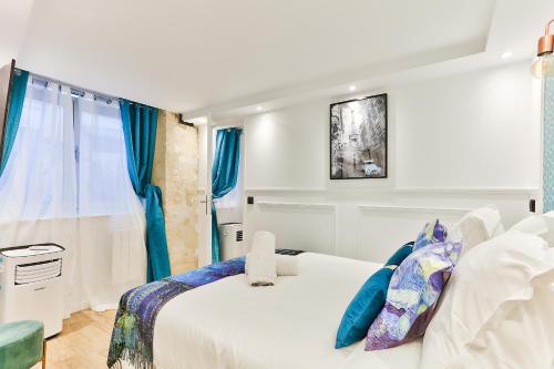 una camera con letto bianco e tende blu di 113 - Urban Vuitton Lemoine a Parigi