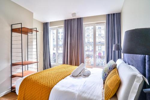 une chambre avec un grand lit avec une couverture jaune dans l'établissement 118 - Urban Luxury Flat La Sorbonne, à Paris