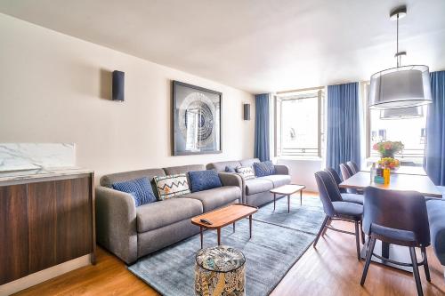 een woonkamer met een bank en een tafel bij 130 - Urban Brand New 110m2 Flat in Montorgueil in Parijs